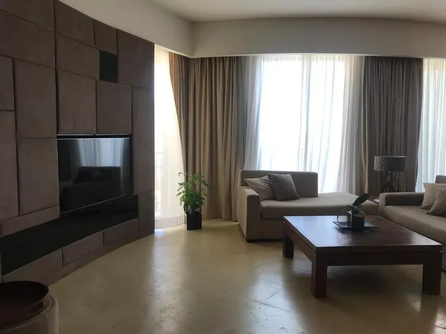 a living room with a couch, coffee table and a window