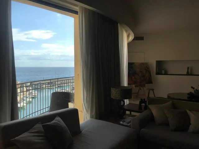a living room with a balcony overlooking the ocean