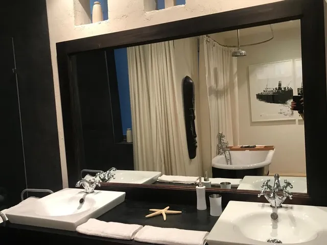 a bathroom with a sink, mirror, and bathtub