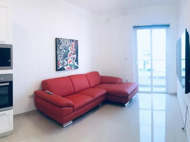 a living room with a couch, coffee table and a television