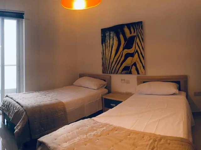 a bedroom with a bed, desk, and a television