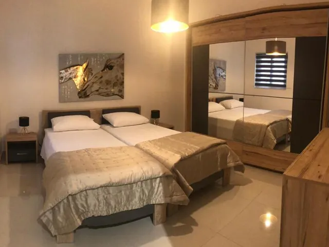 a bedroom with a bed, a desk and a lamp