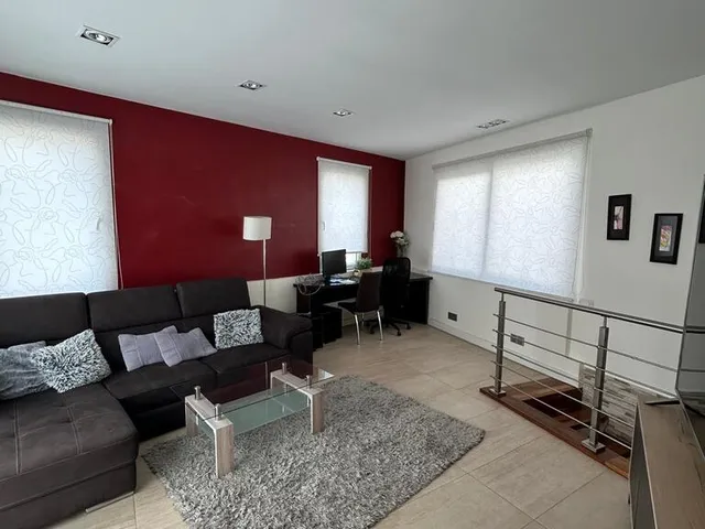 a living room with a couch, coffee table and a window