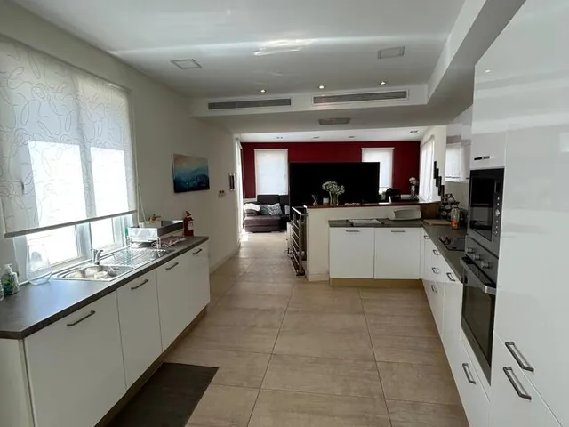 a kitchen with a sink, stove, and a refrigerator