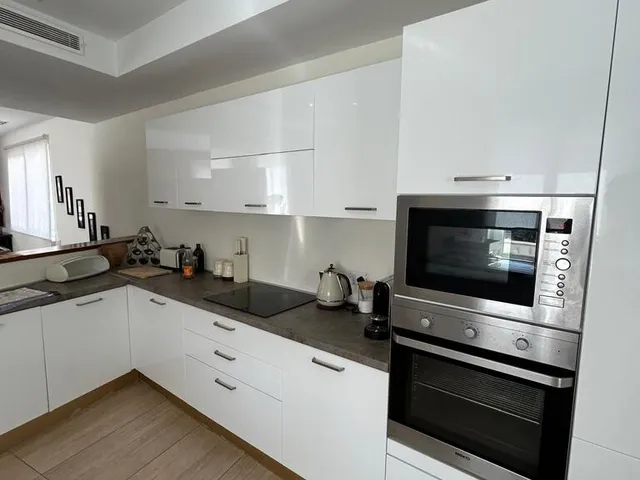a kitchen with a stove, microwave, sink and refrigerator