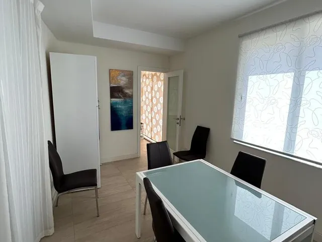 a kitchen with a table and chairs and a window