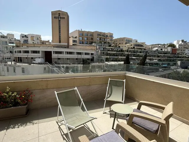a patio with a table and chairs and a building