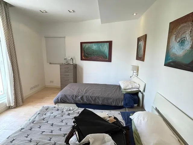 a bedroom with a bed, desk, and a painting