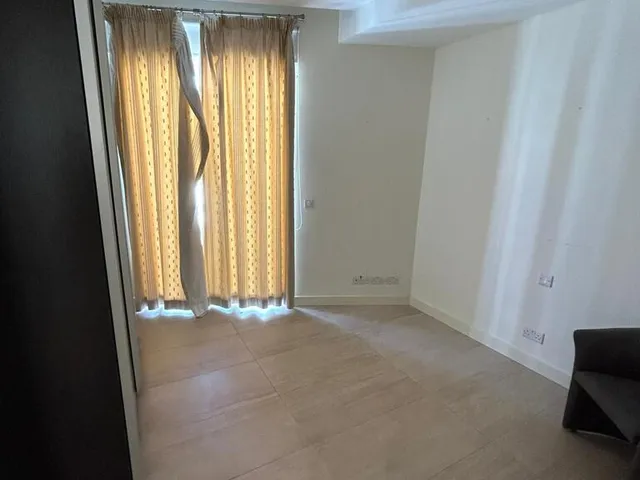 a room with a window and a rug