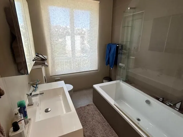 a bathroom with a tub, sink, and window