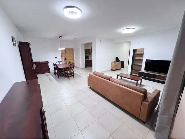 a living room with a couch, coffee table and a television