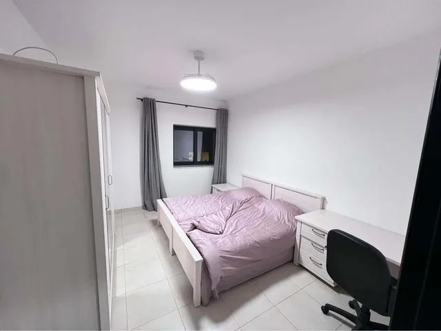 a bed with a white bedspread and pillows