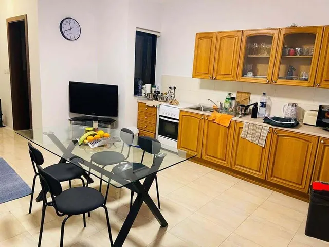 a kitchen with a table and chairs and a refrigerator 