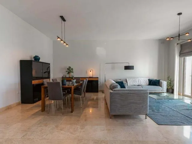 a living room with a couch, table, chairs and a television 