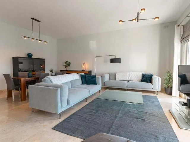 a living room with a couch, chair, table and a television 