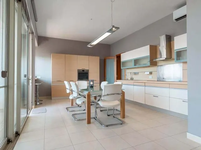 a kitchen with a sink, a refrigerator, and a chair 