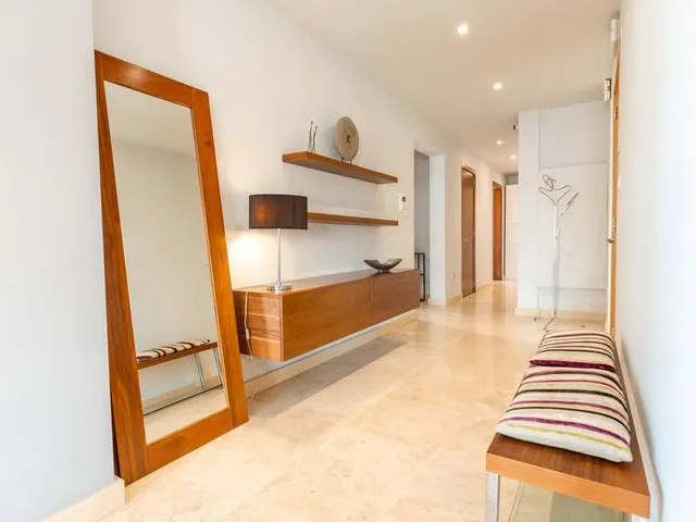 a room with a bed, chair, and a mirror 