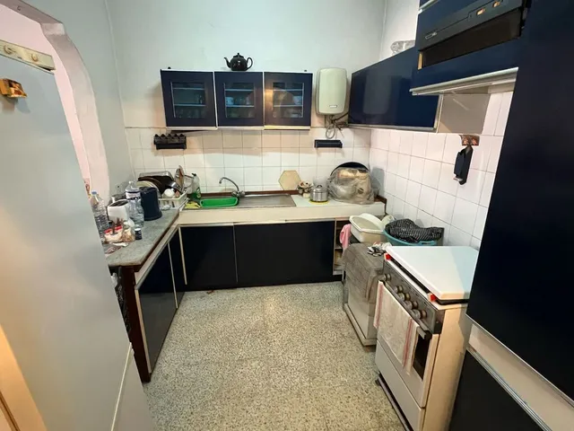 a kitchen with a stove, sink, and cabinets