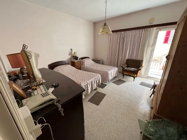 a bedroom with a bed, desk, and a lamp