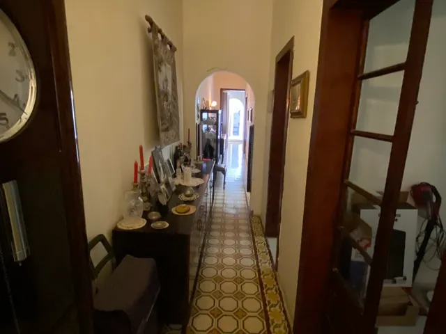a room with a clock and a wall with a rug 