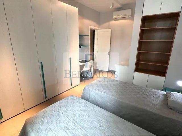 a bedroom with a bed, desk, and a television