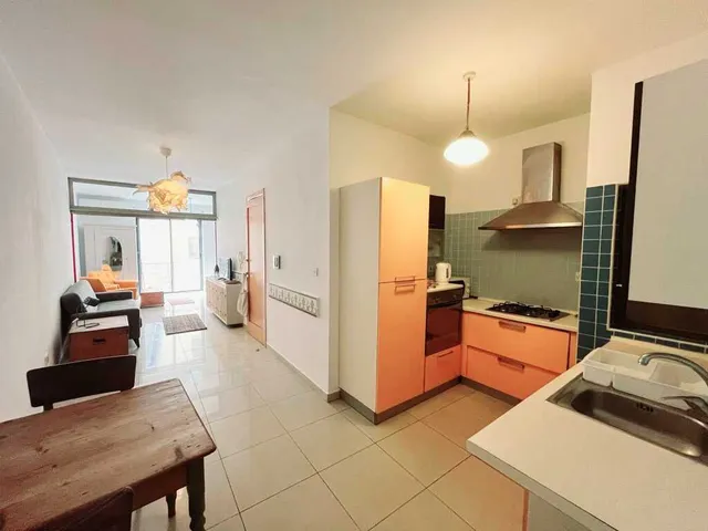 a kitchen with a stove, sink, refrigerator and a table 