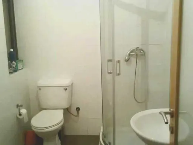 a bathroom with a toilet, shower, and sink 