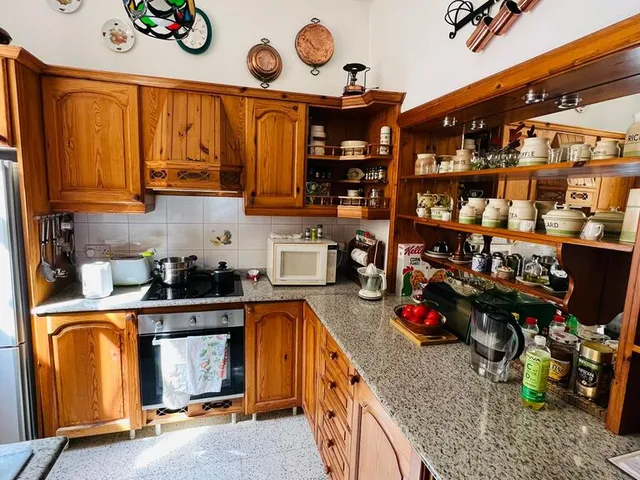 a kitchen with a stove, sink, and cabinets