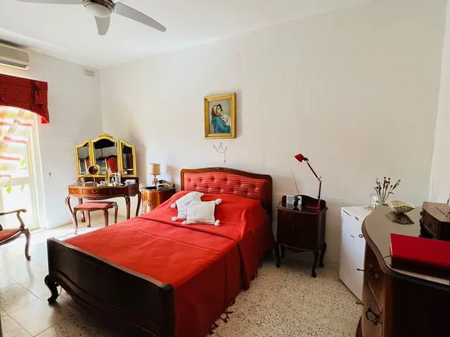 a bedroom with a bed, chair, and a lamp