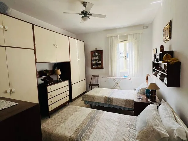 a white bed sitting in a room next to a window