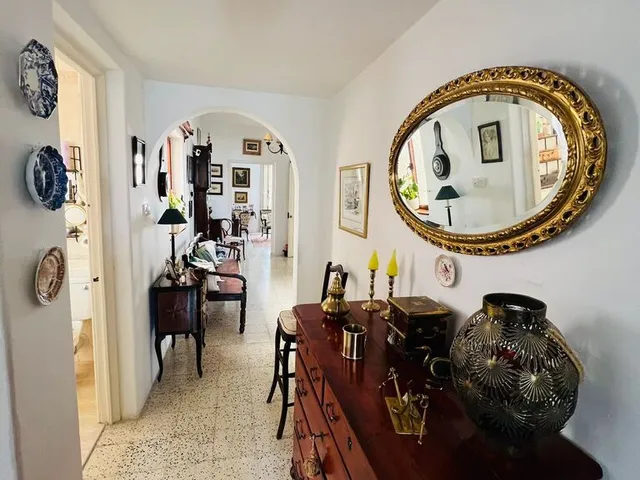 a living room with a mirror, a table, and a mirror above a mirror