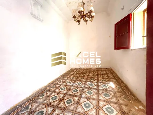 a room with a bed, a rug, and a painting on the wall 