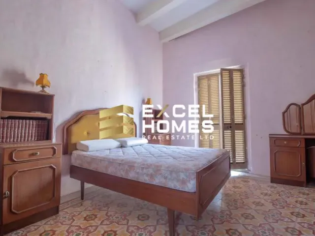 a bedroom with a bed, a dresser, and a window 