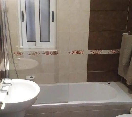 a bathroom with a tub, sink, and mirror 