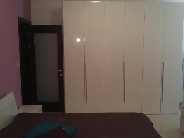a bedroom with a bed, dresser, and a mirror 