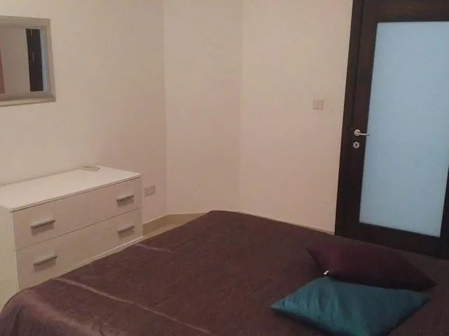 a bedroom with a bed, desk, and television 