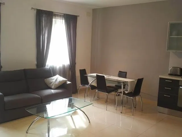 a living room with a couch, table, chairs and a coffee table 