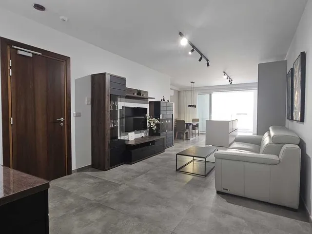 a kitchen with a refrigerator, stove, microwave and a coffee table