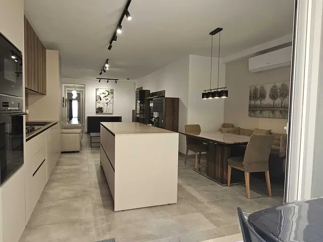 a kitchen with a refrigerator, stove, sink and a table
