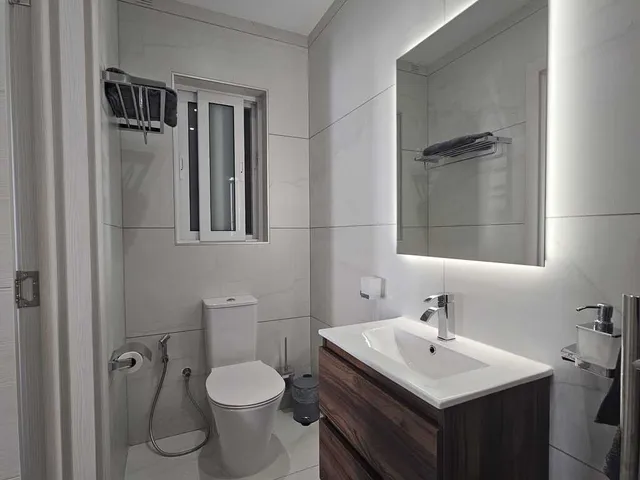 a bathroom with a sink, toilet, and mirror