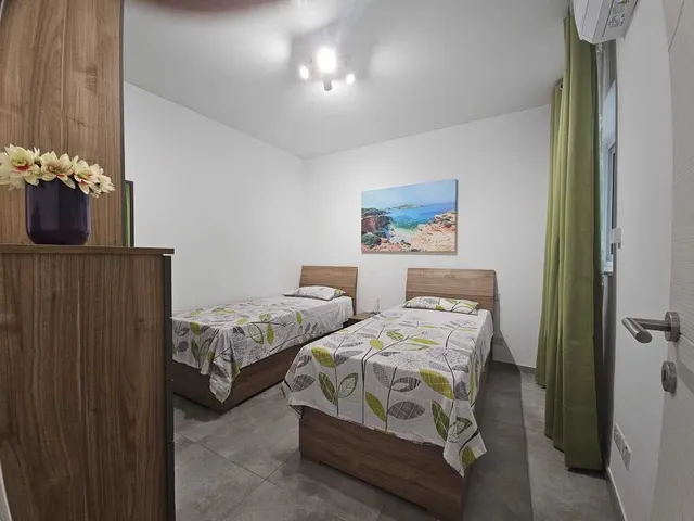 a bedroom with a bed, a desk, and a lamp