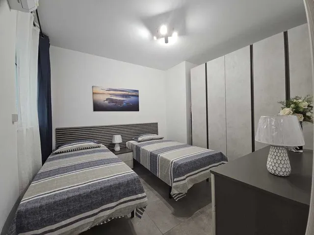 a hotel room with a bed, desk, and television