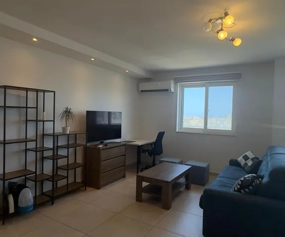 a living room with a couch, chair, and a window