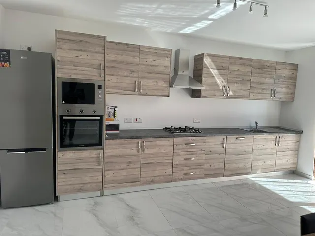 a kitchen with a refrigerator, stove, microwave and a sink 
