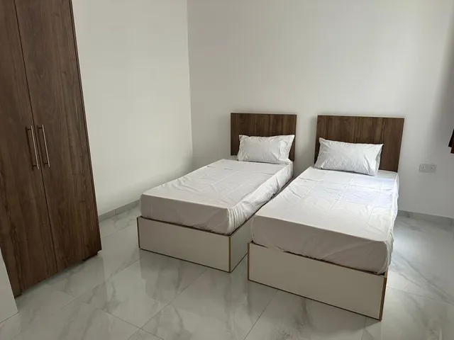 two beds in a room with a white bedspread 