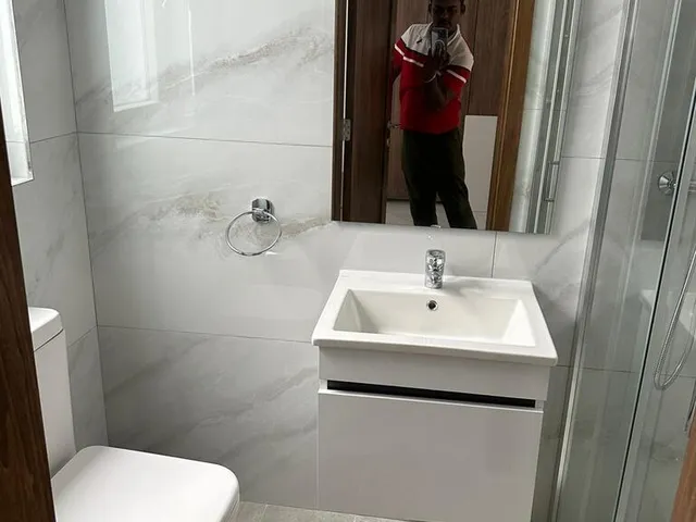 a woman standing in front of a bathroom sink 