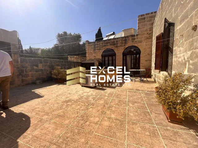 a building with a wooden bench and a brick wall