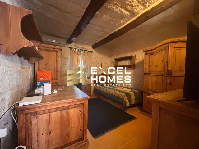 a bedroom with a bed, a stove, and a window