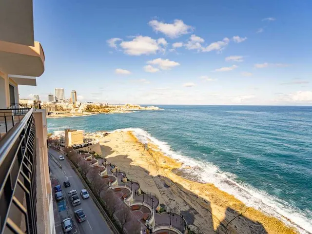 a view from a balcony of a beach with a view of the ocean