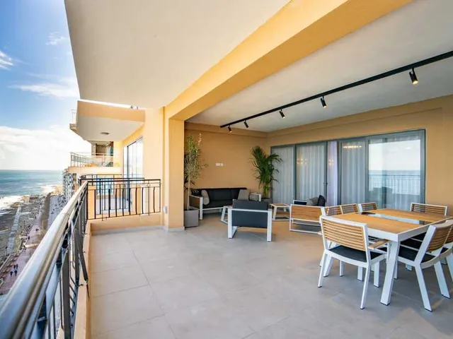 a large patio with a balcony and a dining room